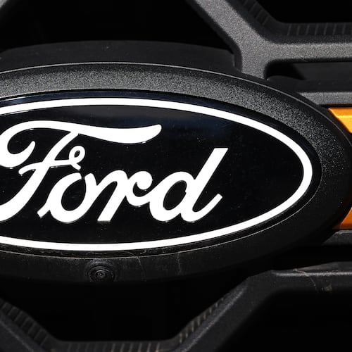 FILE - A Ford logo is seen on the grille of an unsold vehicle at a Ford dealership, Nov. 2, 2025, in Littleton, Colo. (AP Photo/David Zalubowski, File)