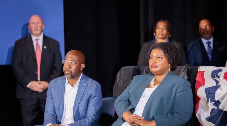 U.S. Sen Raphael Warnock and gubernatorial candidate Stacey Abrams listen to President Barack Obama speak in Atlanta at a rally for Democratic candidates on Oct. 28, 2022. (Arvin Temkar / arvin.temkar@ajc.com)