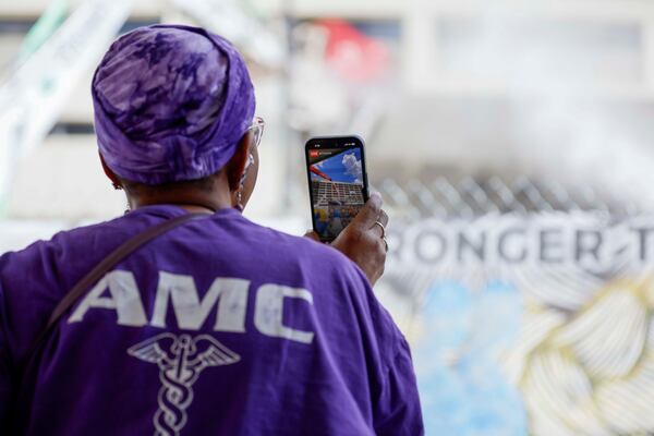 Former Atlanta Medical Center administrator secretary Meta Anthony records a video as heavy equipment begins demolishing the site, marking the start of the project's transformation into a new phase on Monday, June 30, 2025. The AMC served the surrounding communities for over a century. 
(Miguel Martinez/ AJC)