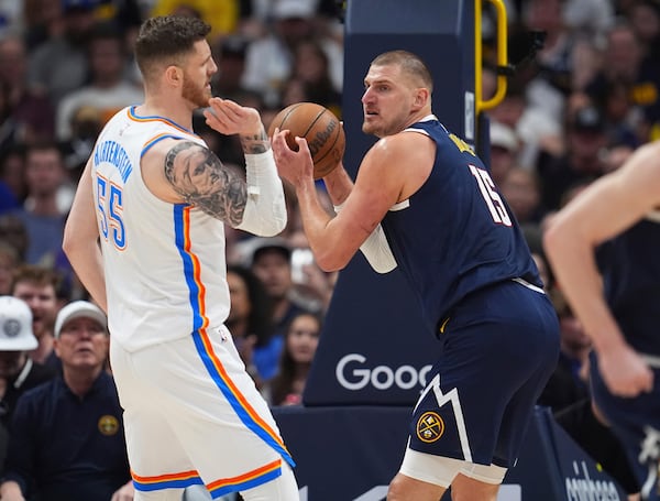 Denver Nuggets center Nikola Jokic, right, pulls in the ball as Oklahoma City Thunder center Isaiah Hartenstein, left, defends in the first half of Game 4 in the Western Conference semifinals of the NBA basketball playoffs Sunday, May 11, 2025, in Denver. (AP Photo/David Zalubowski)