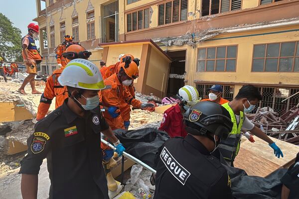 Indian and Myanmar rescuers carry a dead body at U Hla Thein Buddhist monastery that collapsed in Friday's earthquake in Mandalay, Myanmar, Monday, March 31, 2025. (AP Photo/Thein Zaw)