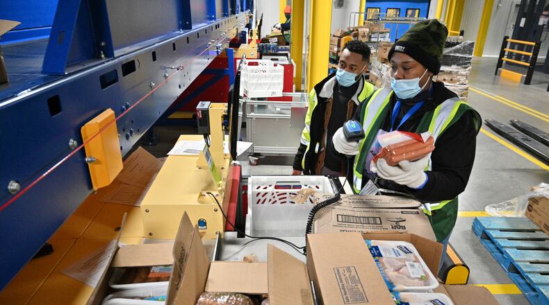 Jessica Milon (right) fulfills online orders as Dmitri Perpignan supervises in the frozen section of the Kroger Delivery Atlanta Fulfillment Center in Forest Park in February 2022. (Hyosub Shin / Hyosub.Shin@ajc.com)