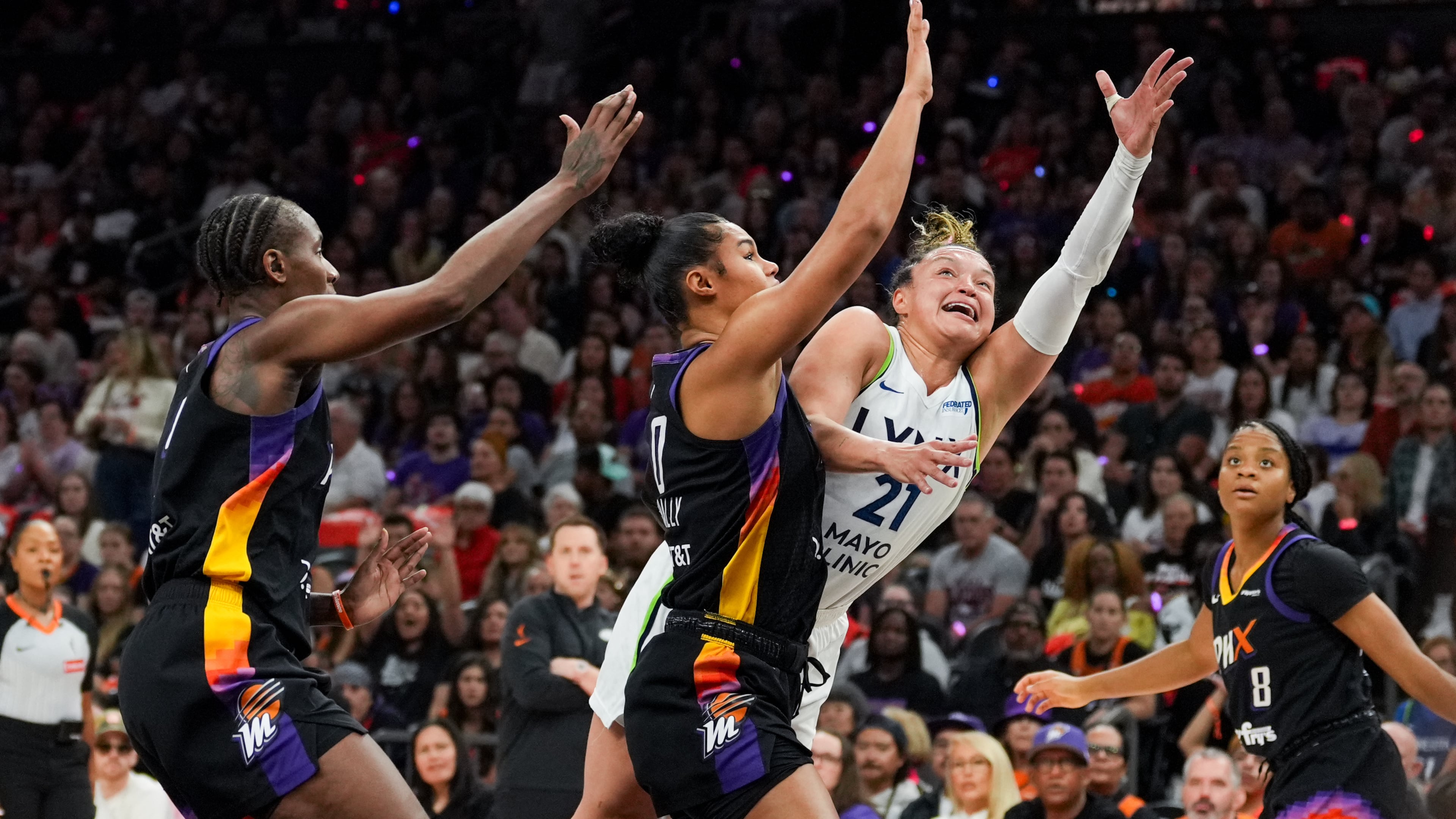 Phoenix Mercury forward Satou Sabally, center, fouls Minnesota Lynx guard Kayla McBride (21) during the first half of Game 4 of a WNBA basketball playoff semifinals series, Sunday, Sept. 28, 2025, in Phoenix. (AP Photo/Samantha Chow)