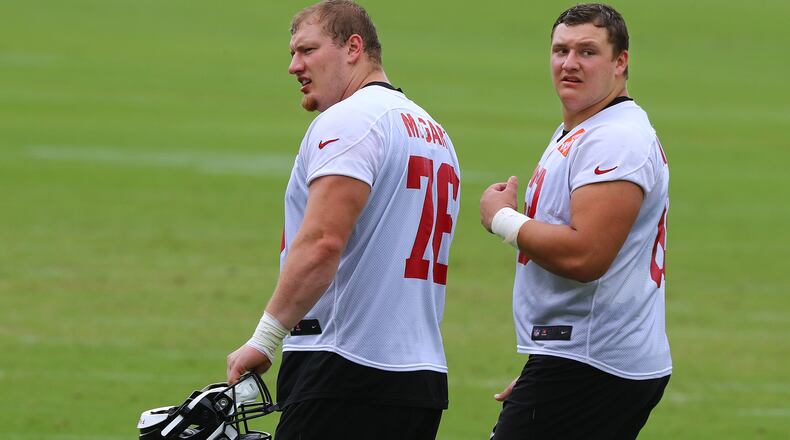 Falcons first-round draft picks Kaleb McGary (left) and Chris Lindstrom walk off the field after practice during minicamp on Wednesday, June 12, 2019, in Flowery Branch.