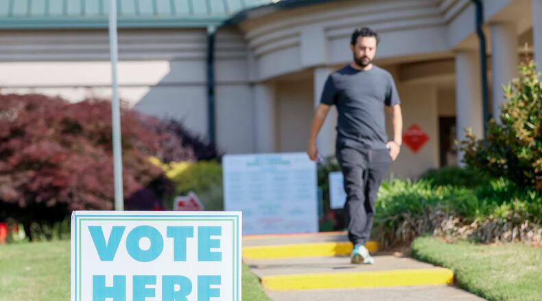 A man walks past a voting sign during the first day of early voting for the primary elections at the Dunwoody Library on Monday, April 27, 2026. (Miguel Martinez/AJC)
