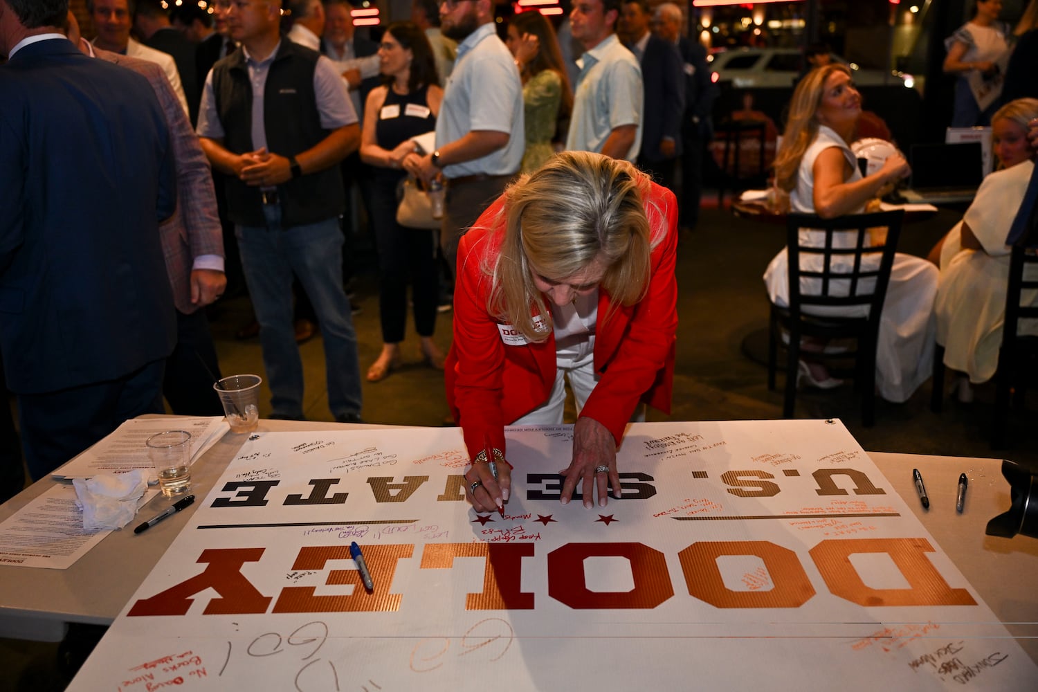 Georgia First Lady Marty Kemp signs a poster in support of Georgia GOP gubernatorial candidate Derek Dooley at his election night party at Park Bench at the Battery during the 2026 Georgia primary elections Tuesday, May 19, 2026, in Atlanta. (Daniel Varnado for the AJC)