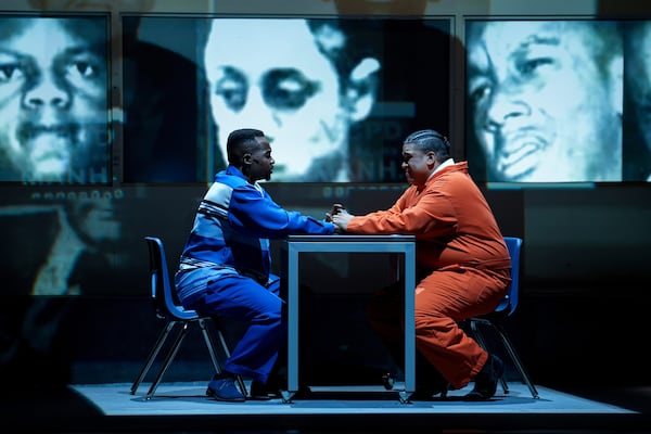 In this photo provided by the Detroit Opera, Babatunde Akinboboye, left, sings the role of Raymond Santana's father, opposite Chaz'men Williams-Ali, who portrays Raymond Santana, in Detroit Opera's performance of Anthony Davis's "The Central Park Five." (Austin T. Richey/Detroit Opera via AP)