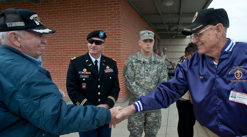 Korean War veteran Bud Farrell, left, and World War II veteran Jim Farmer shake hands Friday at Hutto High School in Hutto, Texas. The school dedicated the day to honoring veterans.