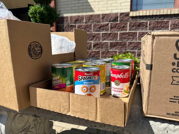 Cans and boxes of food sit on a bench outside the Samaritan Center food pantry in Jefferson City, Mo., on Tuesday, July 1, 2025. (AP Photo/David A. Lieb)
