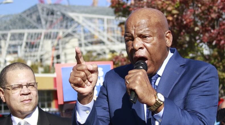 Congressman John Lewis makes a few remarks before leading a march to vote, along with Fulton County Chairman John Eaves (left). They led young Democrats on a march last month from the Nelson Street Bridge to the Fulton County Government Center, where the first day of early voting had begun. BOB ANDRES / BANDRES@AJC.COM