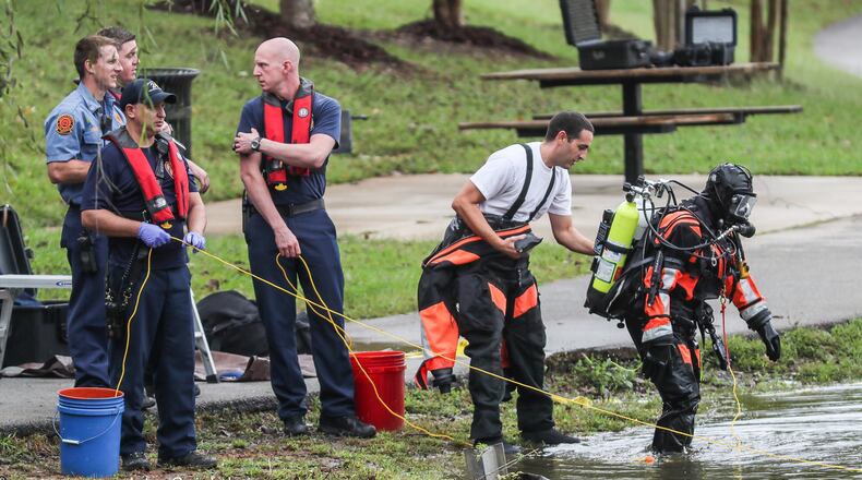 DeKalb County fire and rescue dive members work to pull a car out of McAfee Park Lake in Decatur. The car went in the lake Wednesday, but officials are not yet sure how it got in there.  JOHN SPINK/JSPINK@AJC.COM