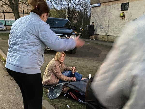 A woman holds a hand of her husband killed by a Russian rocket strike at a residential neighbourhood in Kryvyi Rih, Ukraine, April 4, 2025. 14 civilians were killed including six children. (Na Chasi media via AP)