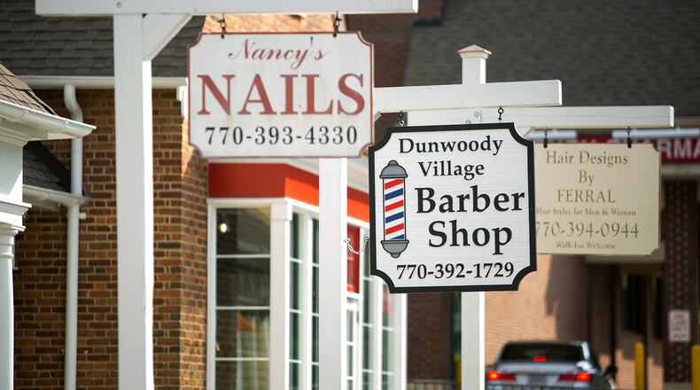 Signs for businesses are shown at Dunwoody Village on Friday, May 15, 2015, in Dunwoody, Ga. PHOTO / JASON GETZ
