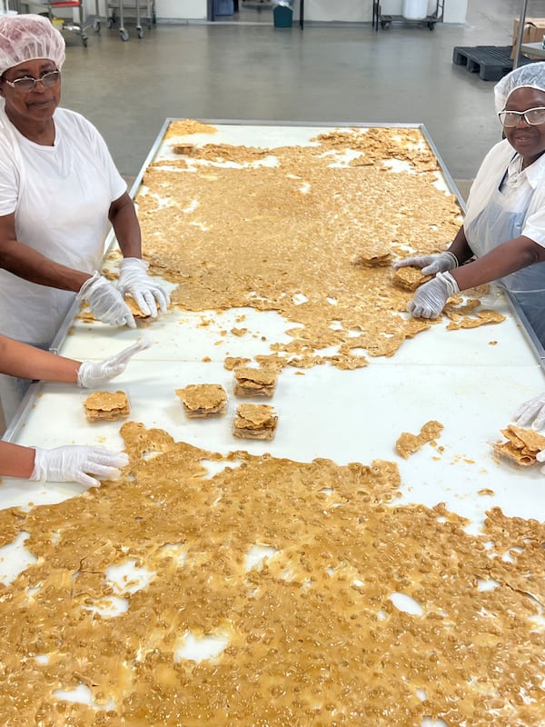 The hot mixture for Dillon Candy Company’s pecan or peanut brittle is poured from a copper kettle onto the candy tables and then stretched by hand so the pieces are extra thin. (Courtesy of Dillon Candy Company)