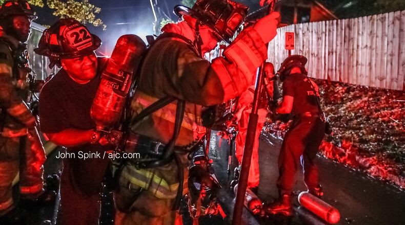 DeKalb County firefighters work to put out the flames at a home on Apple Valley Road in Brookhaven on Thursday morning.