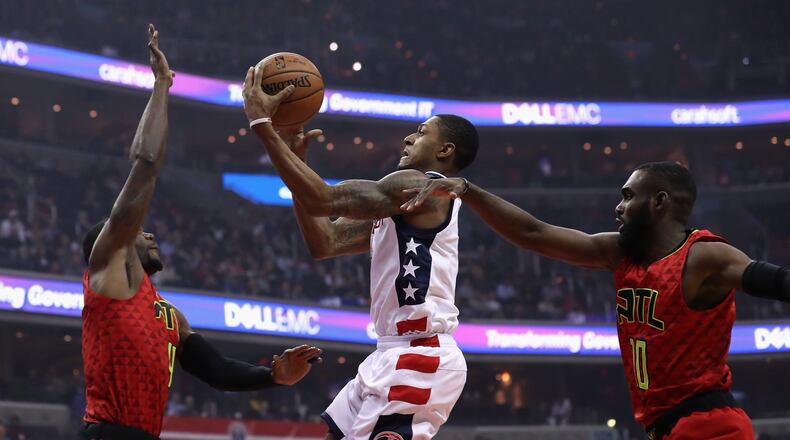 Bradley Beal of the Washington Wizards puts up a shot in front of Paul Millsap (left) and Tim Hardaway Jr. (right) of the Atlanta Hawks in the first half during Game 5 of the Eastern Conference Quarterfinals during the 2017 NBA Playoffs at at Verizon Center on April 26, 2017 in Washington, DC. (Photo by Rob Carr/Getty Images)