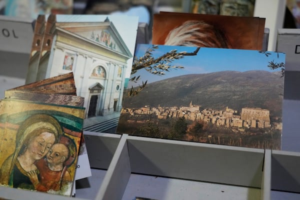 Postcards of the Sanctuary of Our Mother of Good Counsel, left, and of Genazzano, are displayed inside the sanctuary, Thursday, May 15, 2025. (AP Photo/Gregorio Borgia)