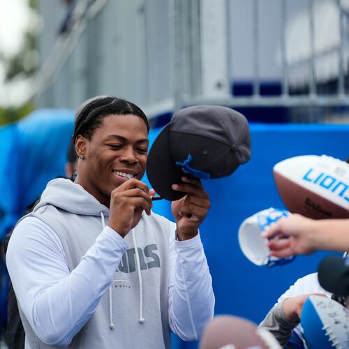 Detroit Lions running back Jahmyr Gibbs signs autographs for fans after practice at the NFL football team's training camp, in Allen Park, Mich., Sunday, Aug. 2, 2026. (AP Photo/Paul Sancya)