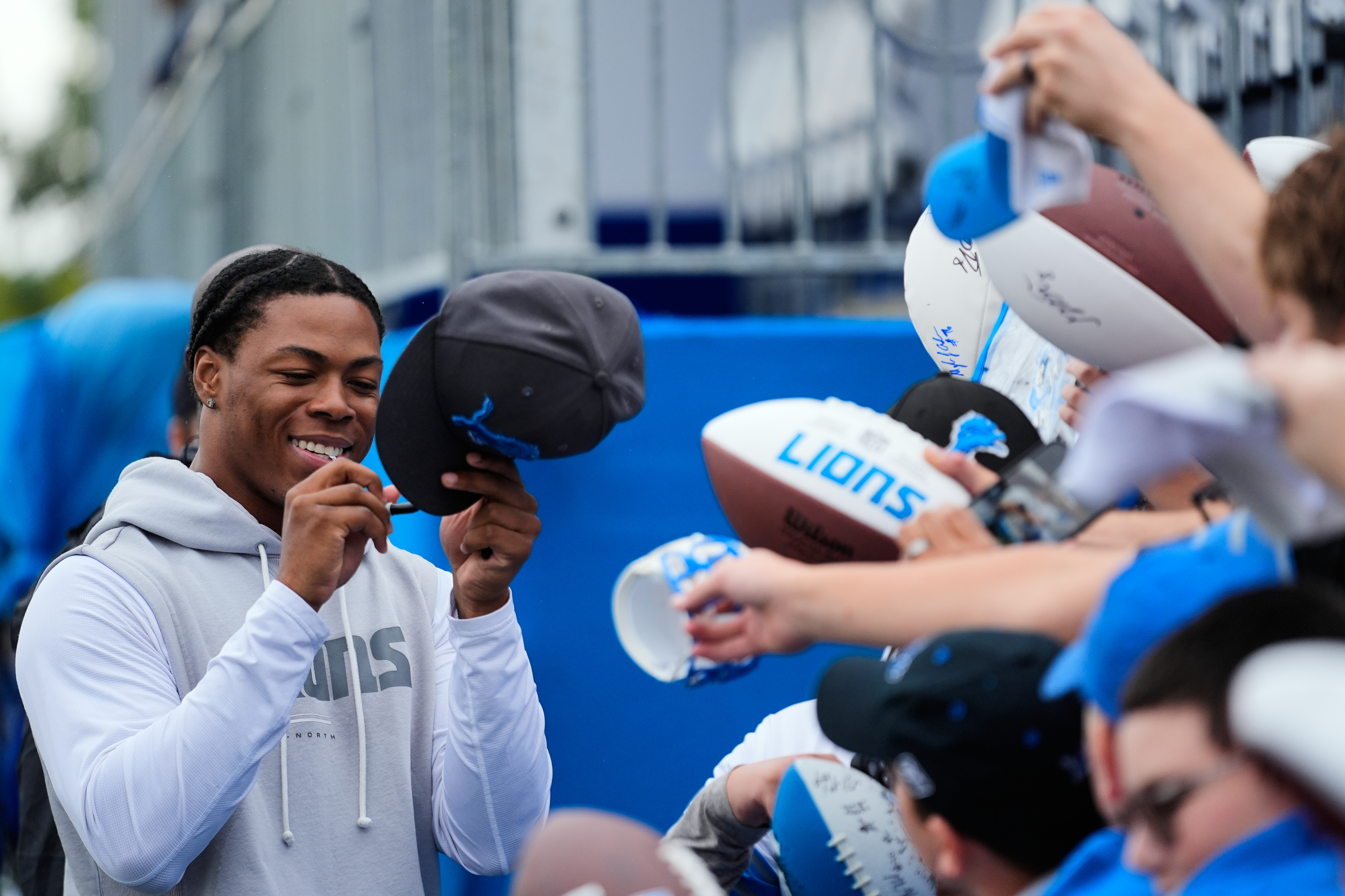Detroit Lions running back Jahmyr Gibbs signs autographs for fans after practice at the NFL football team's training camp, in Allen Park, Mich., Sunday, Aug. 2, 2026. (AP Photo/Paul Sancya)