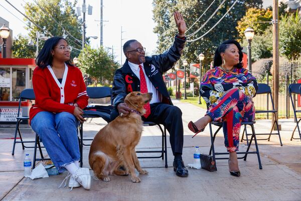 Clark Atlanta University President George French (center) sits with his family during the homecoming parade in Atlanta on Saturday, October 15, 2022.   (Arvin Temkar / arvin.temkar@ajc.com)
