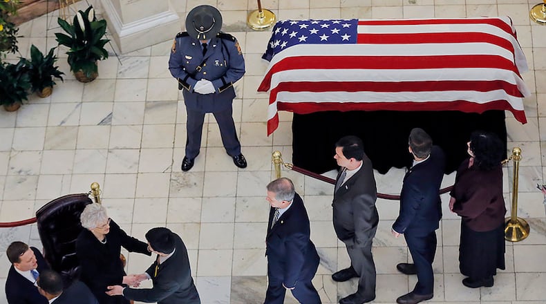 Former Gov. Zell Miller lies in state in the rotunda of the Capitol as legislators file in to pay their respects to former first lady Shirley Miller (left). He was brought to the Capitol on Tuesday after a service at Peachtree Road United Methodist Church. Legislators lined the steps of the Capitol as his casket was carried the the rotunda, where he will lie in state until Wednesday afternoon. BOB ANDRES /BANDRES@AJC.COM