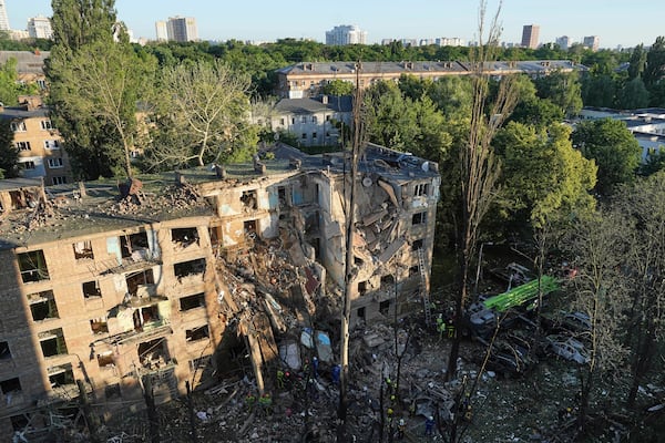 Firefighters work in a destroyed apartment building after a Russian attack in Kyiv, Ukraine, early Monday, June 23, 2025. (AP Photo/Efrem Lukatsky)