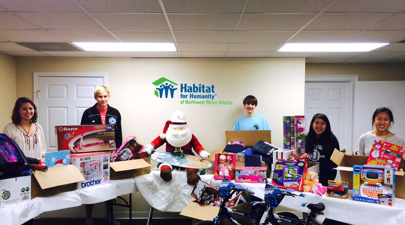 Students in Pope High School’s Habitat for Humanity chapter delivered four carloads of presents to give to four families at Christmastime.