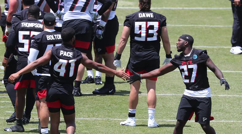 Safety Richie Grant (right) gets five from JR Pace after a play against the offense during rookie minicamp on Friday, May 14, 2021, in Flowery Branch. “Curtis Compton / Curtis.Compton@ajc.com”
