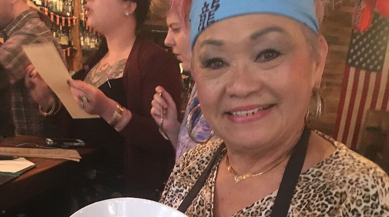 Betty Hsu holds her Malaysian Yellow Curry Chicken at the Chinese New Year party at Sweet Auburn BBQ in February.