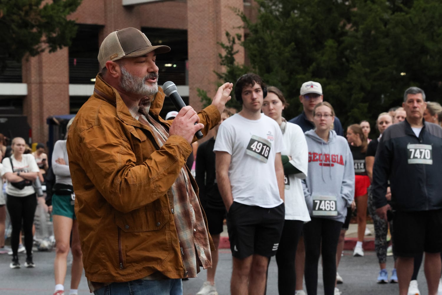 Jonathan Jackson, worship and student pastor at NewGrace Church in Commerce, Ga., gives a blessing in the parking lot of UGA’s Tate Student Center on Saturday, Feb. 21, 2026, before a 5K walk/run and memorial service for Augusta University nursing student Laken Riley. Riley was attacked on Feb. 22, 2024 while running in Oconee Forest Park on the UGA campus and killed. Riley had previously attended UGA and was an avid runner. (C.J. Bartunek for the AJC)
