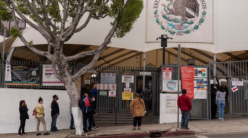FILE - People line up for services at the Mexican Consulate in Los Angeles, May 8, 2021. (AP Photo/Damian Dovarganes, File)