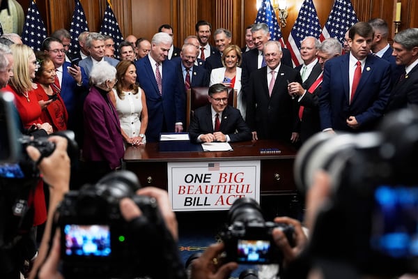 Speaker of the House Mike Johnson, R-La., surrounded by Republican members of Congress, signs President Donald Trump's signature bill of tax breaks and spending cuts, Thursday, July 3, 2025, at the Capitol in Washington. (AP Photo/Julia Demaree Nikhinson)