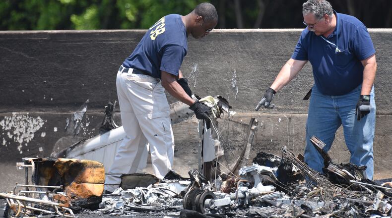 May 8, 2015 Atlanta - NTSB Safety Investigator Eric Alleyne (left) and other official investigate on I-285 at Peachtree Industrial Boulevard, where four people died aboard a small plan on Friday, May 8, 2015. Traffic was shut down in both directions. Three men and one woman were killed in the crash, according to Channel 2 Action News. The National Transportation Safety Board is in charge of the investigation and will determine probable cause. HYOSUB SHIN / HSHIN@AJC.COM