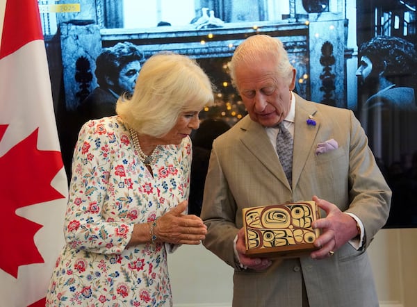 Britain's King Charles and Queen Camilla look at the Key to Canada House which was presented to the King by High Commissioner for Canada, Ralph Goodale, during a visit to Canada House to mark 100 years since it opened, in London, Tuesday, May 20, 2025. (Arthur Edwards/Pool via AP)