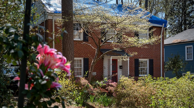 Flowers attached to a speed limit sign sit outside a home on Garden Lane in Decatur in honor of 31-year-old Henry Doyle Colon “Hank” Frantz, whose body was found in a backyard treehouse this month. Ben Hendren for The Atlanta Journal-Constitution