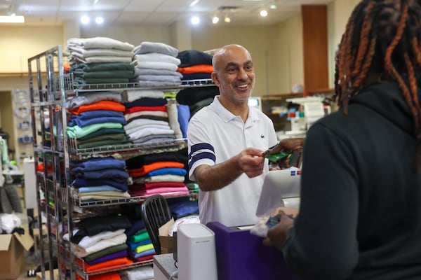 Stitch by Stitch owner Selcuk Ozcelebi helps a customer at his store at North Point Mall in Alpharetta on April 10, 2026. (Arvin Temkar/AJC)