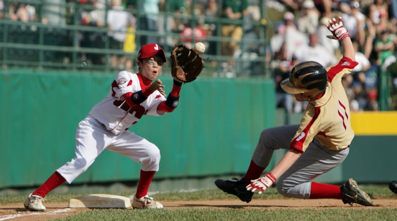 Keaton Allen slides safely into third base for the Southeast Champions, the Warner Robins American Little League, in their game against Tokyo Kitasuna Little League, representing Japan, for the Little League World Series Championship at Williamsport, PA today, 8/25/07. Kazutaka Kato took the late throw. (LOUIE FAVORITE / STAFF)