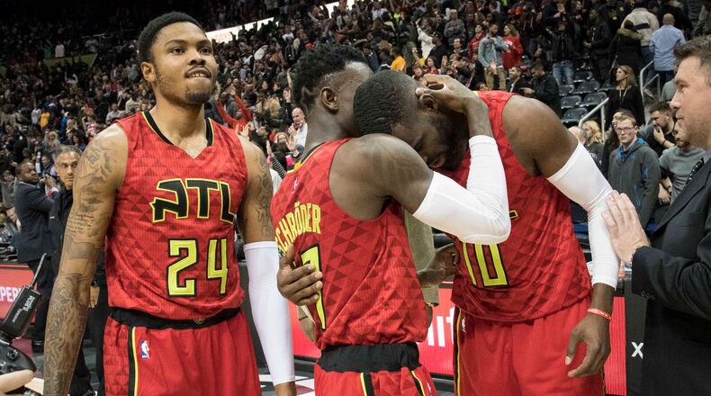 Atlanta Hawks guards Tim Hardaway Jr. (10) and Dennis Schroder congratulate each other as forward Kent Bazemore (24) watches after the team’s NBA basketball game against the San Antonio Spurs, Sunday, Jan. 1, 2017, in Atlanta. Atlanta won 114-112 in overtime. (AP Photo/John Amis)