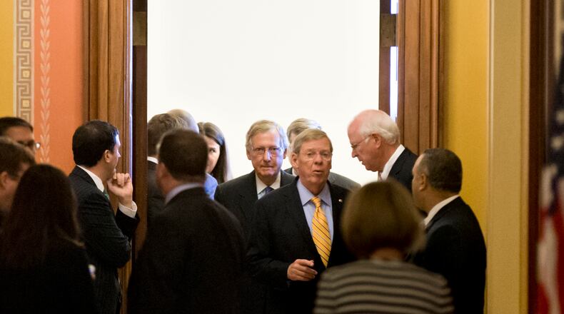 Senate Minority Leader Mitch McConnell, R-Ky., center, emerges from a closed-door meeting with Republican senators at the Capitol in Washington, Wednesday, Oct. 16, 2013. McConnell and his Democratic counterpart, Senate Majority Leader Harry Reid, D-Nev., reached last-minute agreement Wednesday to avert a threatened Treasury default and reopen the government after a partial, 16-day shutdown. Sen. Johnny Isakson, R-Ga., center right, speaks with Sen. Saxby Chambliss, R-Ga., right. (AP Photo/J. Scott Applewhite) Senate Minority Leader Mitch McConnell, R-Ky., center, emerges from a closed-door meeting with at the Capitol in Washington during the 2013 federal shutdown. Sen. Johnny Isakson, R-Ga., center right, speaks with then-Sen. Saxby Chambliss, R-Ga., right. AP/J. Scott Applewhite