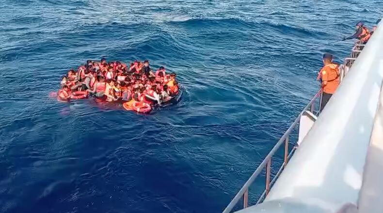 In this photo made from video released by the Indonesian National Search and Rescue Agency (BASARNAS), crew pull survivors from a passenger ferry Putri Yasmin that caught fire while traveling from the tourist island of Bali to neighboring island of Lombok toward a rescue ship in the waters of Lombok Strait, Indonesia, Wednesday, Aug. 12, 2026. (BASARNAS via AP)