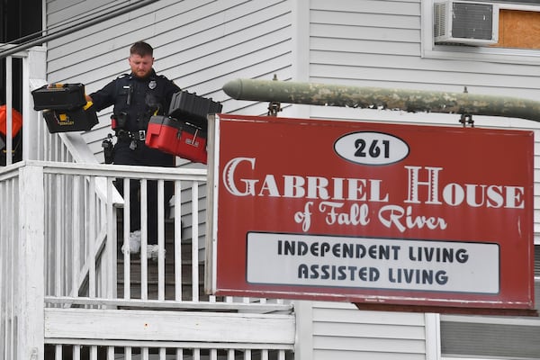 A law enforcement official removes boxes containing patient medications from the Gabriel House assisted living facility following a fire that resulted in multiple fatalities, in Fall River, Mass., Monday, July 14, 2025. (AP Photo/Steven Senne)