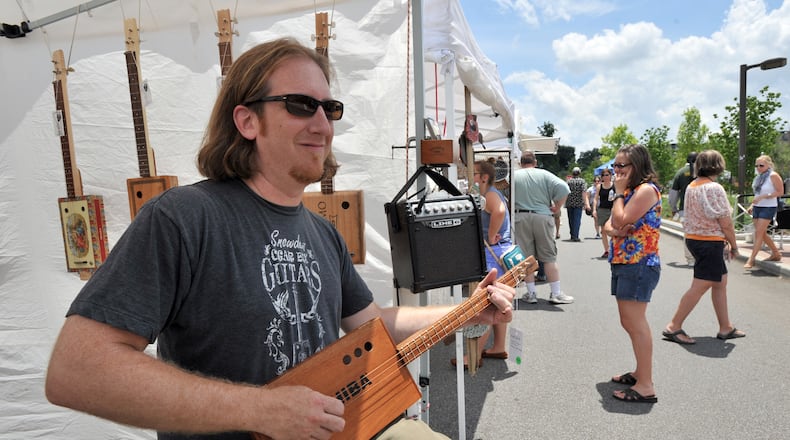 Cigar box guitars, like this one played by Mike Snowden of Marietta during the Old Fourth Ward Park Arts Festival, will be available for checkout from Fulton County libraries.