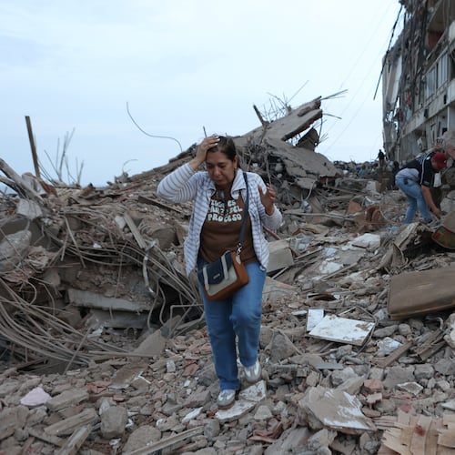 Residents walk among the rubble of building damaged in earthquakes the previous day in Catia La Mar, Venezuela, Thursday, June 25, 2026. (AP Photo/Pedro Mattey)