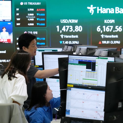 Currency traders watch monitors near a screen showing the Korea Composite Stock Price Index (KOSPI), top center, and the foreign exchange rate between U.S. dollar and South Korean won, top center left, at the foreign exchange dealing room of the Hana Bank headquarters in Seoul, South Korea, Wednesday, April 15, 2026. (AP Photo/Ahn Young-joon)