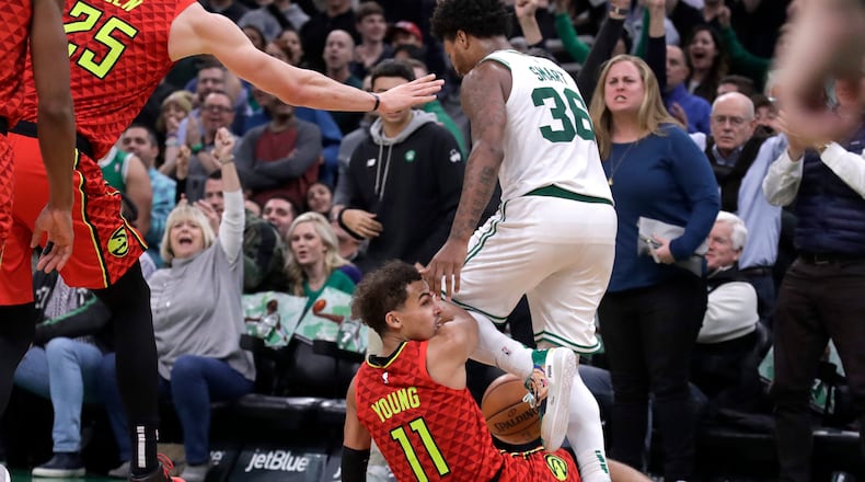 Boston Celtics guard Marcus Smart (36) steps over Hawks guard Trae Young (11), leading to a scuffle in the last seconds of an NBA basketball game Friday, Jan. 3, 2020, in Boston. The Celtics won 109-106. (AP Photo/Elise Amendola)