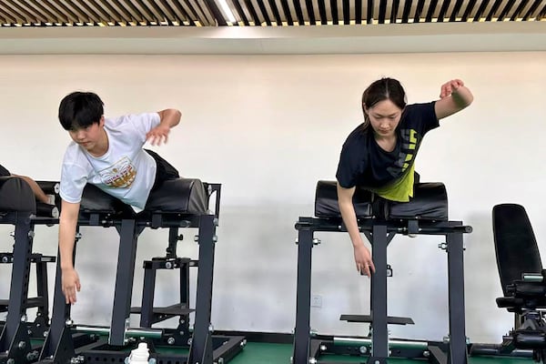 In this photo taken Jan. 15, 2025, and released by Hebei Taihua Jinye Swimming Club, 12 years old Chinese swimmer Yu Zidi, left and teammate Li Bingjie, right train together in the land training room at Hebei Taihua Jinye Swimming Club in Hengshui city, Hebei province, China. (Hebei Taihua Jinye Swimming Club via AP)