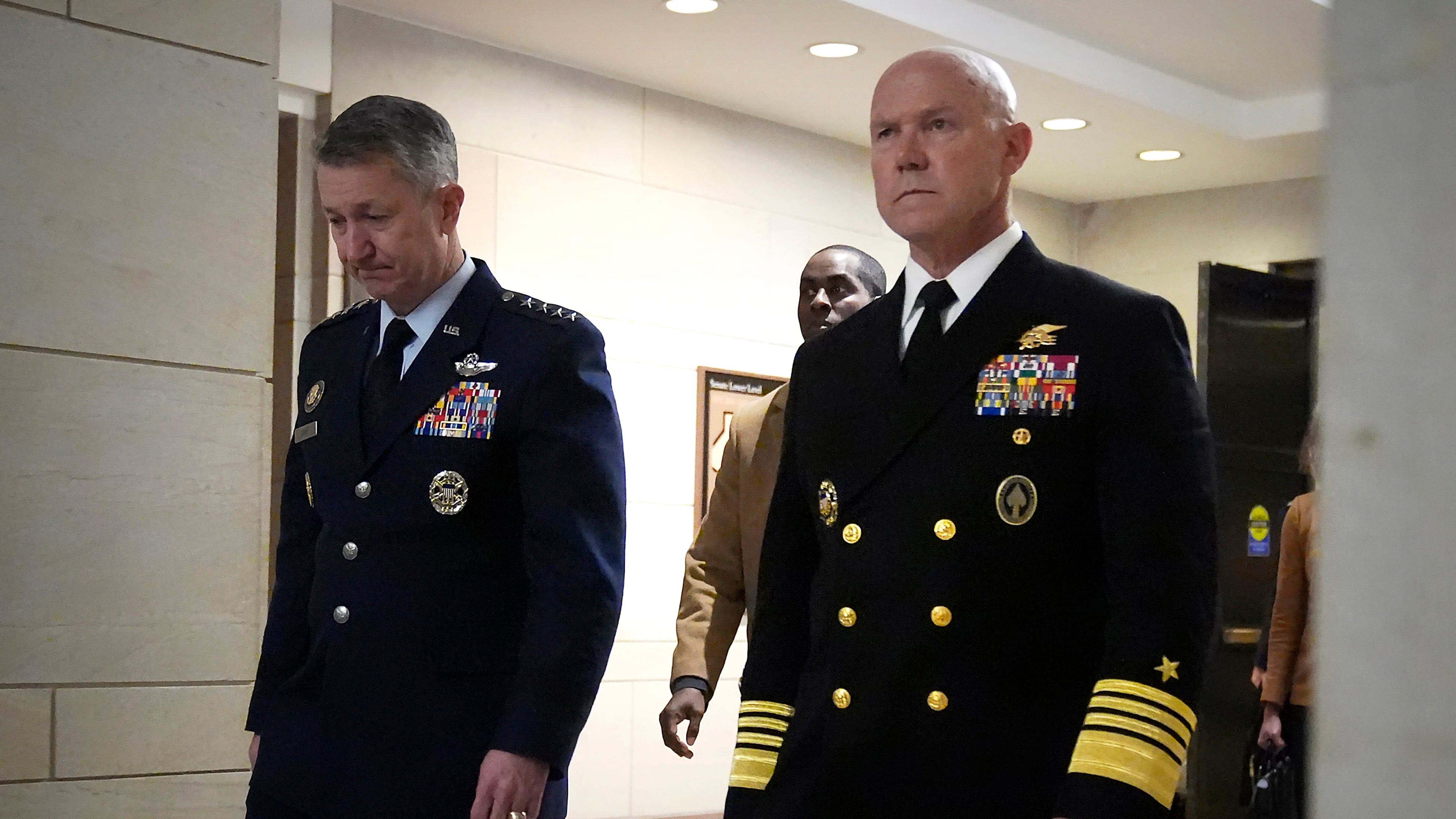 U.S. Navy Adm. Frank M. Bradley, right, accompanied by Gen. Dan Caine, chairman of the Joint Chiefs of Staff, left, walks to a meeting with senators on Capitol Hill, Thursday, Dec. 4, 2025, in Washington. (AP Photo/Mark Schiefelbein)