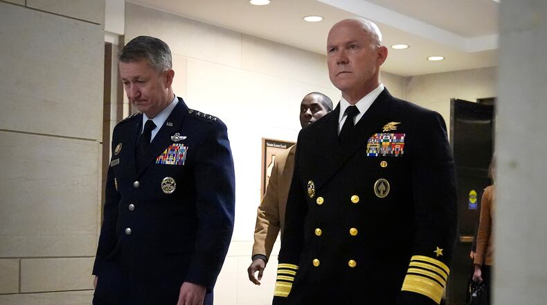 U.S. Navy Adm. Frank M. Bradley, right, accompanied by Gen. Dan Caine, chairman of the Joint Chiefs of Staff, left, walks to a meeting with senators on Capitol Hill, Thursday, Dec. 4, 2025, in Washington. (AP Photo/Mark Schiefelbein)
