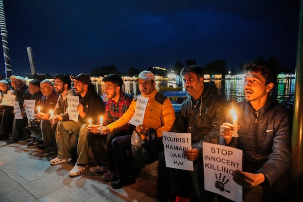 Kashmiri men hold candles and placards as they condemn the tourists killing during a protest in Srinagar, Indian controlled Kashmir, Thursday, April. 24, 2025. (AP Photo/Dar Yasin)