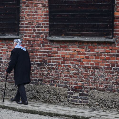 Holocaust survivor Stanislaw Zalewski walks along a wall in the Auschwitz Nazi death camp museum during a ceremony marking the 81th anniversary of the camp's liberation in Oswiecim, Poland, Tuesday, Jan. 27, 2026. (AP Photo/Beata Zawrzel)